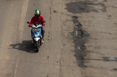 Kendaraan bermotor melintasi ruas jalan yang berlubang dan bergelombang di Jalan Rasuna Said, Jakarta Selatan, Rabu (16/2/2022).
