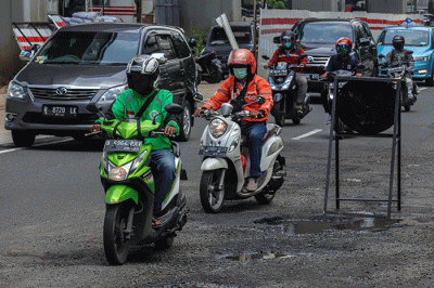 Kendaraan bermotor melintasi ruas jalan yang berlubang dan bergelombang di Jalan Rasuna Said, Jakarta Selatan, Rabu (16/2/2022).