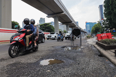 Kendaraan bermotor melintasi ruas jalan yang berlubang dan bergelombang di Jalan Rasuna Said, Jakarta Selatan, Rabu (16/2/2022).