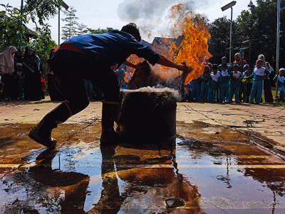 Petugas Dinas Pemadam Kebakaran Kabupaten Bogor melakukan teknik memadamkan api di depan orang tua, guru dan murid PAUD di kawasan Ciseeng, Bogor.