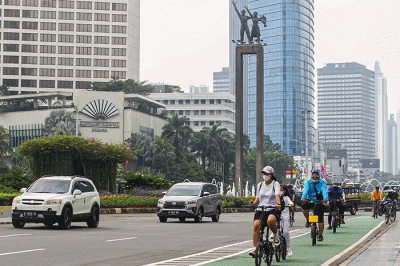 Warga bersepeda di Jalan Jenderal Sudirman, Jakarta, Minggu (20/2/2022).