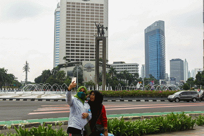 Warga bersepeda di Jalan Jenderal Sudirman, Jakarta, Minggu (20/2/2022).