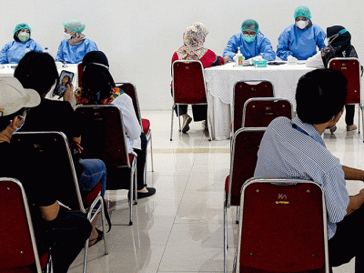 Tenaga Kesehatan menyuntikan vaksin booster Pfizer dan Astrazeneca ke warga untuk mencegah penyebaran Covid-19 di Depok, Jawa Barat, Senin (21/2/2022).