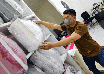 Penjual menata barang dagangannya berupa produk bahan sprei perlengkapan tempat tidur yang dipasarkan melalui online di toko orisa bedding, Jakarta Selatan.