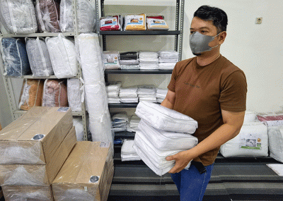 Penjual menata barang dagangannya berupa produk bahan sprei perlengkapan tempat tidur yang dipasarkan melalui online di toko orisa bedding, Jakarta Selatan.