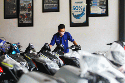 Sales menawarkan motor ke calon konsumen di salah satu dealer motor di kawasan Cibubur, Jakarta Timur, Kamis (3/3/2022).