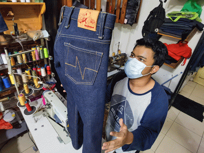 Penjual saat menyelesaikan pembuatan celana custom dan memasarkannya secara online di toko nyoel jeans, Jakarta Barat, Kamis (3/3/2022).