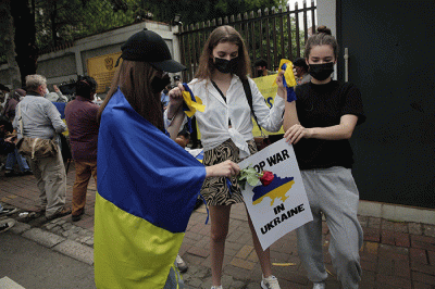 Pengunjuk rasa yang tergabung dalam Solidaritas untuk Rakyat Ukraina membentangkan bendera Ukraina saat aksi damai di depan Kedutaan Besar Rusia.