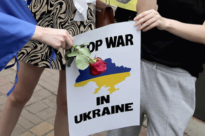 Pengunjuk rasa yang tergabung dalam Solidaritas untuk Rakyat Ukraina membentangkan bendera Ukraina saat aksi damai di depan Kedutaan Besar Rusia.