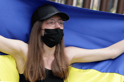 Pengunjuk rasa yang tergabung dalam Solidaritas untuk Rakyat Ukraina membentangkan bendera Ukraina saat aksi damai di depan Kedutaan Besar Rusia.