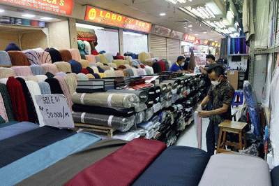 Seorang pedagang menata kain tekstil dagangannya di Pasar Tanah Abang, Jakarta, Sabtu (5/3/2022).