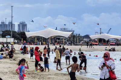 Pengunjung menikmati pantai ancol, Jakarta, Minggu (6/3/2022).