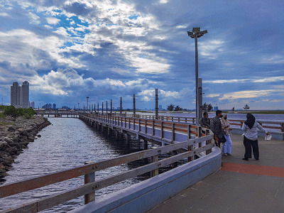Pengunjung menikmati pantai ancol, Jakarta, Minggu (6/3/2022).