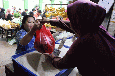 Pedagang beras melayani pembeli di kawasan Pasar Inpres Serdang, Kemayoran, Jakarta, Sabtu (12/3/2022).