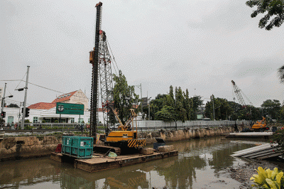 Pekerja menyelesaikan pemasangan dinding turap di kali pasar baru, Jakarta, Sabtu (12/3/2022).