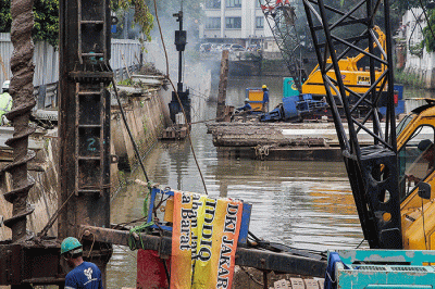 Pekerja menyelesaikan pemasangan dinding turap di kali pasar baru, Jakarta, Sabtu (12/3/2022).