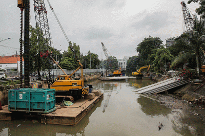 Pekerja menyelesaikan pemasangan dinding turap di kali pasar baru, Jakarta, Sabtu (12/3/2022).
