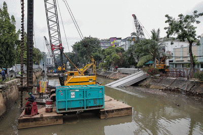 Pekerja menyelesaikan pemasangan dinding turap di kali pasar baru, Jakarta, Sabtu (12/3/2022).