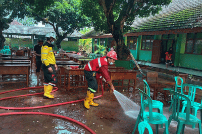 Tim Keselamatan dan Kesehatan Kerja (K3) SIG membantu membersihkan fasilitas umum yang terendam lumpur akibat banjir.