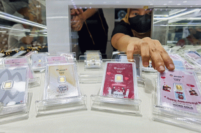 Pedagang menunjukan produk emas Batangan gift series di Toko Hartadinata Abadi, Cikini Gold Center, Jakarta, Senin (14/3/2022).