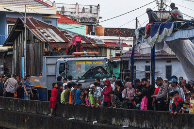 Petugas mengevakuasi mobil jenis Daihatsu Xenia bernomor polisi BG 1162 RR warna silver dari dalam sungai Jembatan Gledek, Palembang, Minggu (13/3/2022).