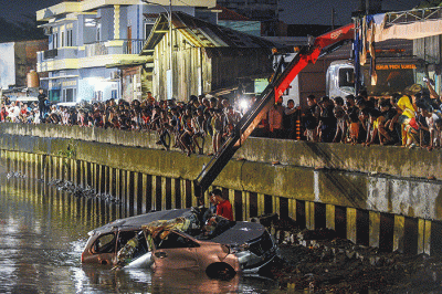Petugas mengevakuasi mobil jenis Daihatsu Xenia bernomor polisi BG 1162 RR warna silver dari dalam sungai Jembatan Gledek, Palembang, Minggu (13/3/2022).