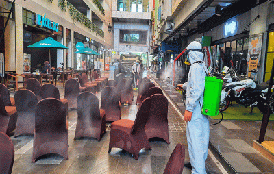 Petugas melakukan penyemprotan disinfektan di area Mall Ratu Indah, Makassar, Minggu (13/3/2022).