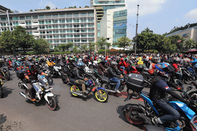 Warga memotret pembalap motoGP usai mengikuti parade di kawasan Bundaran HI, Jakarta, Rabu (16/3/2022).
