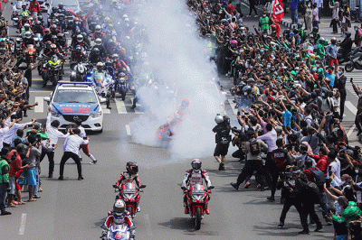 Pembalap MotoGP Marc Márquez melakukan aksi burn out saat parade jelang MogoGP Mandalika di kawasan Sarinah, Thamrin, Jakarta Pusat, Rabu (16/3/2022).