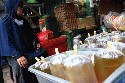 Pedagang melayani pembeli minyak curah dan minyak kemasan di kawasan pasar Kemayoran Jakarta, Rabu (16/3/2022).