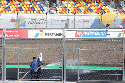 Petugas menyiramkan air ke lintasan Pertamina Mandalika International Street Circuit, di Lombok Tengah, NTB, Kamis (17/3/2022).
