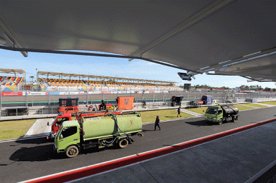 Petugas menyiramkan air ke lintasan Pertamina Mandalika International Street Circuit, di Lombok Tengah, NTB, Kamis (17/3/2022).