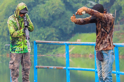 Warga saat memancing ikan dengan cara inovatif menggunakan modifikasi senapan angin di Situ Gintung, Tangerang Selatan, Kamis (17/3/2022).