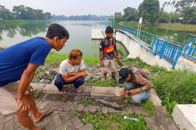 Warga saat memancing ikan dengan cara inovatif menggunakan modifikasi senapan angin di Situ Gintung, Tangerang Selatan, Kamis (17/3/2022).