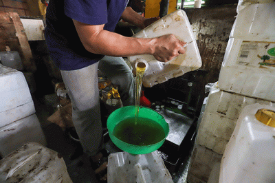 Penjual memasukkan minyak goreng curah ke dalam jerigen di Kawasan Pasar Cipete, Jakarta Selatan, Kamis (17/3/2022).