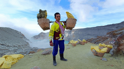 Penambang memikul belerang di Kawah Ijen, Banyuwangi, Jawa Timur, Jumat (18/3/2022).