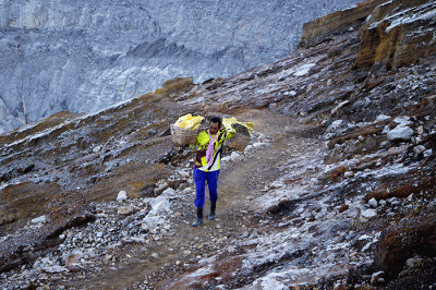 Penambang memikul belerang di Kawah Ijen, Banyuwangi, Jawa Timur, Jumat (18/3/2022).
