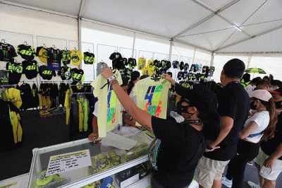 Sejumlah penonton membeli pernak-pernik berupa kaos dan topi VR46 yang merupakan merek apparel milik legenda MotoGP Valentino Rossi.