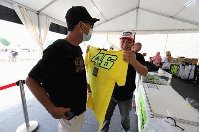 Sejumlah penonton membeli pernak-pernik berupa kaos dan topi VR46 yang merupakan merek apparel milik legenda MotoGP Valentino Rossi.