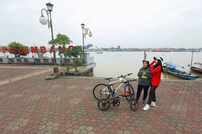 Warga bersepeda menikmati kota Palembang, Minggu (20/3/2022).