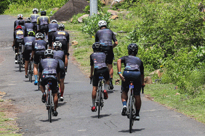 Peserta Bike To Care 2022 #BaliLoop 500 Km menunjukkan medali usai melintasi garis finish etape dua di Sol Benoa, Badung, Bali, Minggu (20/3/2022).