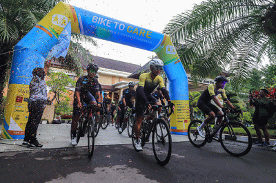 Peserta Bike To Care 2022 #BaliLoop 500 Km menunjukkan medali usai melintasi garis finish etape dua di Sol Benoa, Badung, Bali, Minggu (20/3/2022).