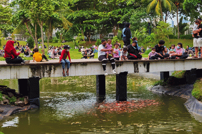 Warga mengisi libur akhir pekan dengan menikmati senja di hutan kota Kawasan Gelora Bung Karno, Jakarta, Minggu (20/3/2022).