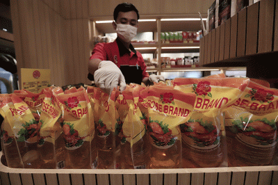Karyawan toko menata minyak goreng di Jakarta, Kamis (24/3/2022).