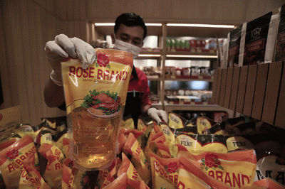 Karyawan toko menata minyak goreng di Jakarta, Kamis (24/3/2022).