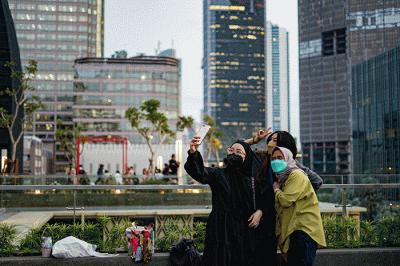 Pengunjung saat berswafoto dengan latar belakang gedung bertingkat di Skydeck Mal Sarinah, Jakarta Pusat, Rabu (23/3/2022).