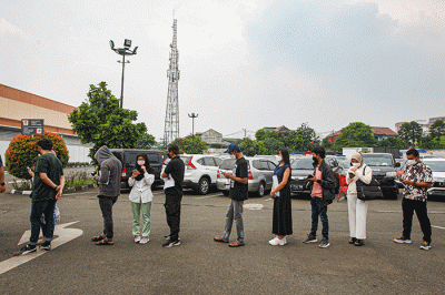 Vaksinator menyuntikkan vaksin Covid-19 kepada warga di Lotte Grosir, Jakarta, Jumat, (25/3/2022).
