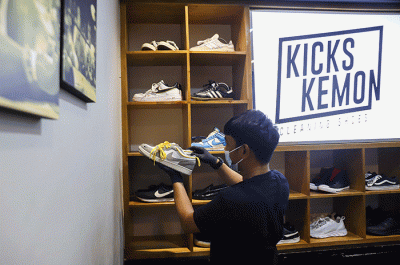 Pekerja membersihkan sepatu pelanggan di Cleaning Shoes Kicks Kemon, Haji Nawi, Jakarta Selatan, Sabtu (26/3/2022).