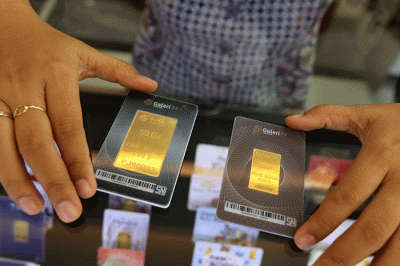 Petugas menunjukan emas batangan di Galeri 24 Pegadaian, Jakarta, Selasa (29/3/2022).