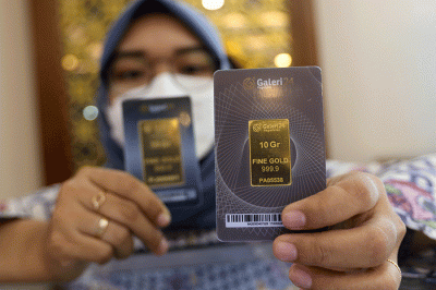 Petugas menunjukan emas batangan di Galeri 24 Pegadaian, Jakarta, Selasa (29/3/2022).